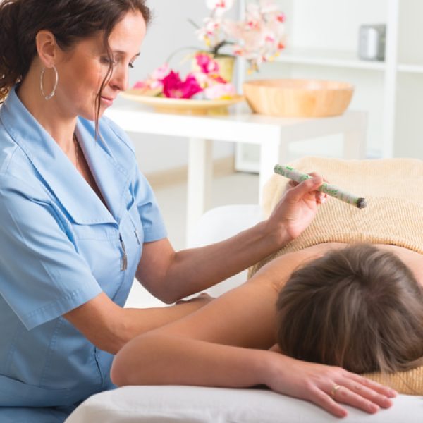 Alternative medicine therapist doing moxa treatment on her client